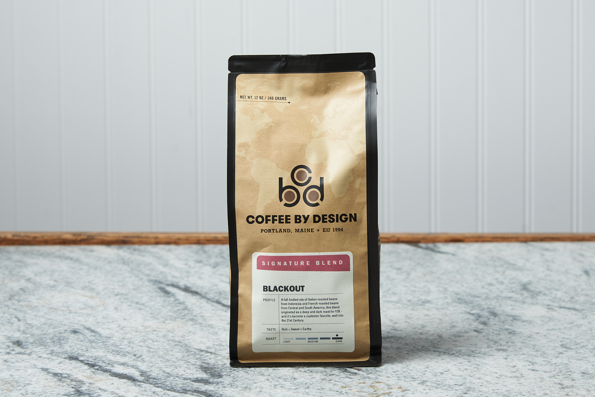 A bag of Coffee By Design Blackout coffee sits on a marble countertop.