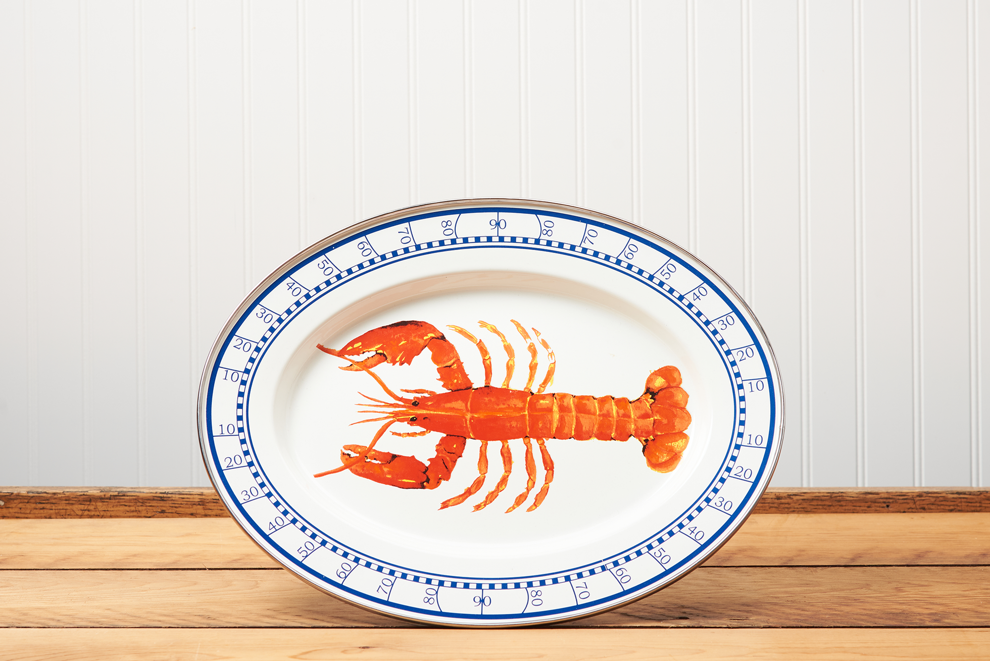 A Golden Rabbit Lobster Oval Platter sitting on a brown wooden table.