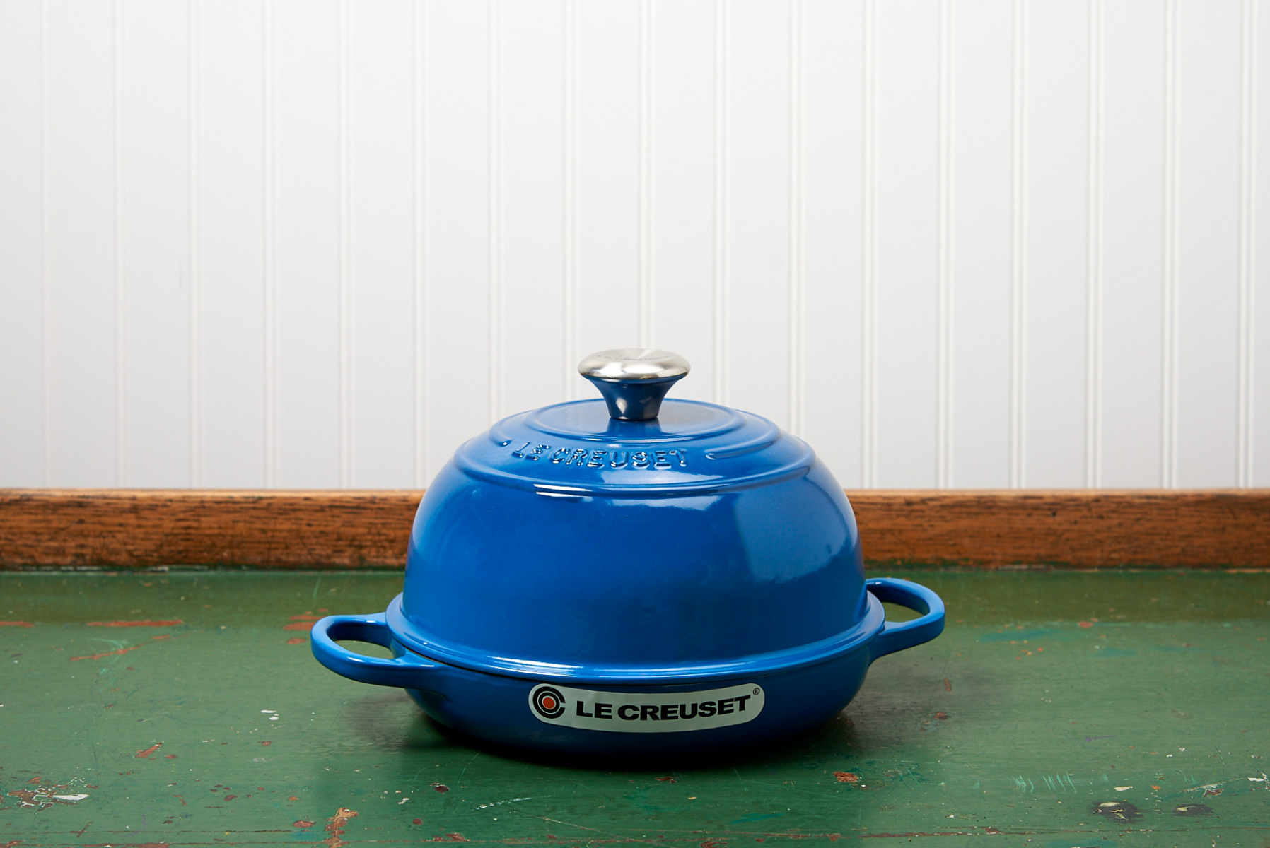 Blue enameled cast iron Le Creuset Dutch oven on a wooden table