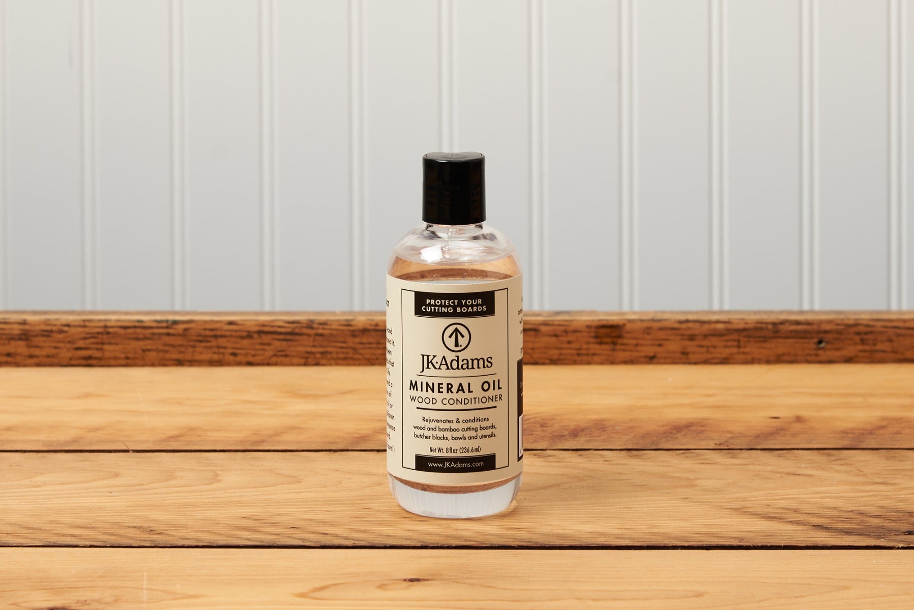 Bottle of JKAdams mineral oil wood conditioner on wooden surface