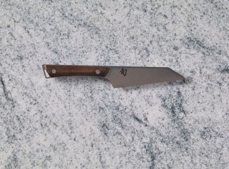 A Shun Kanso 5" Honesuki Multi Prep Knife on a marble countertop.