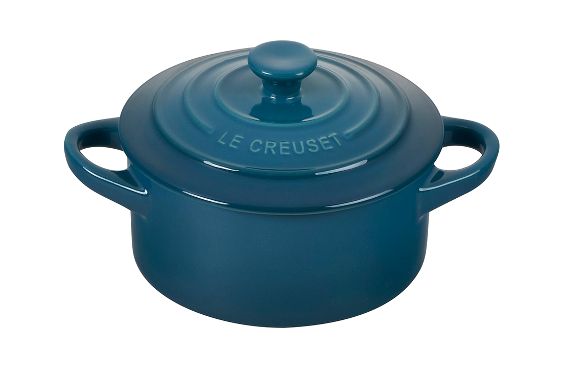 Blue Le Creuset cast iron cooking pot with lid on white background