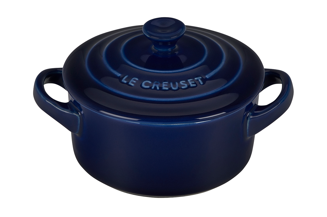 Navy blue Le Creuset stoneware casserole dish on white background
