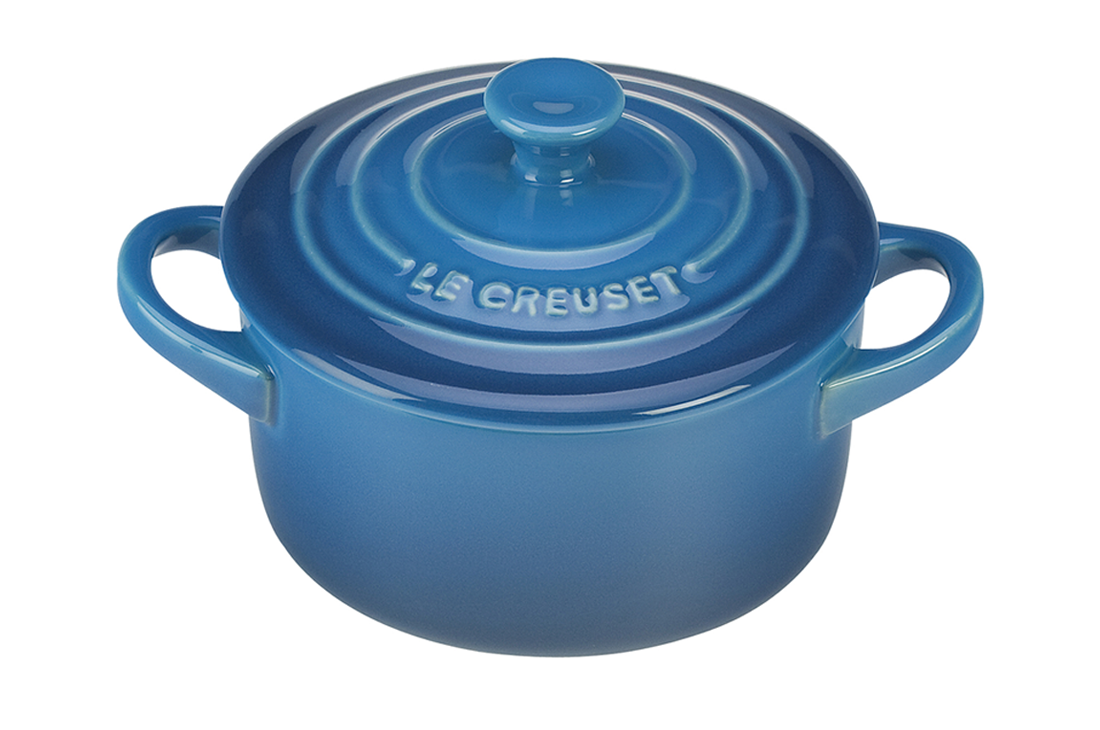 Blue enameled cast iron Dutch oven by Le Creuset on white background