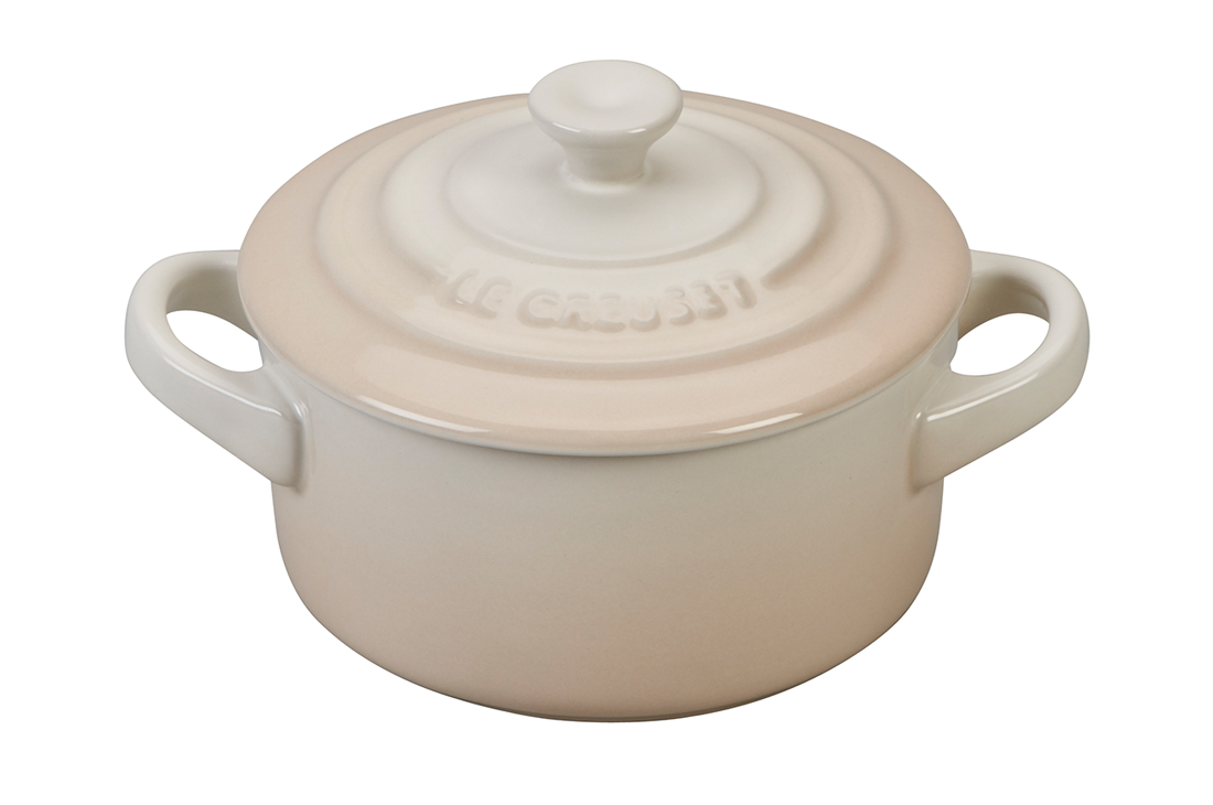Beige ceramic casserole dish with lid on white background