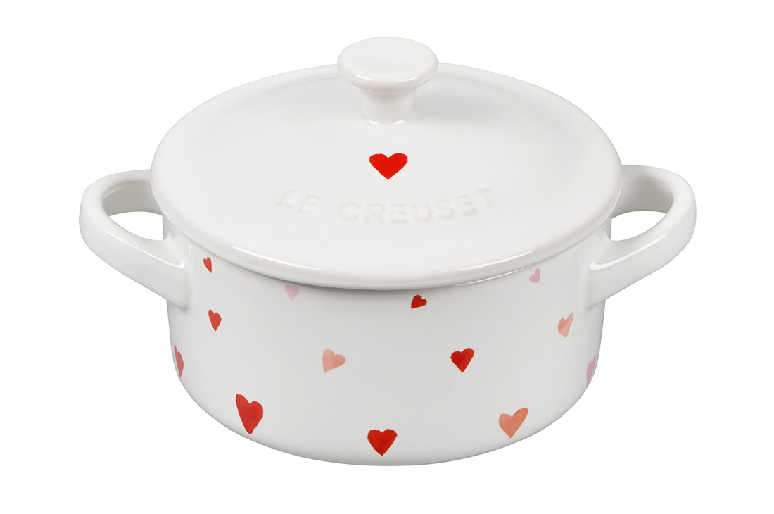 White Le Creuset pot with red heart pattern on isolated background