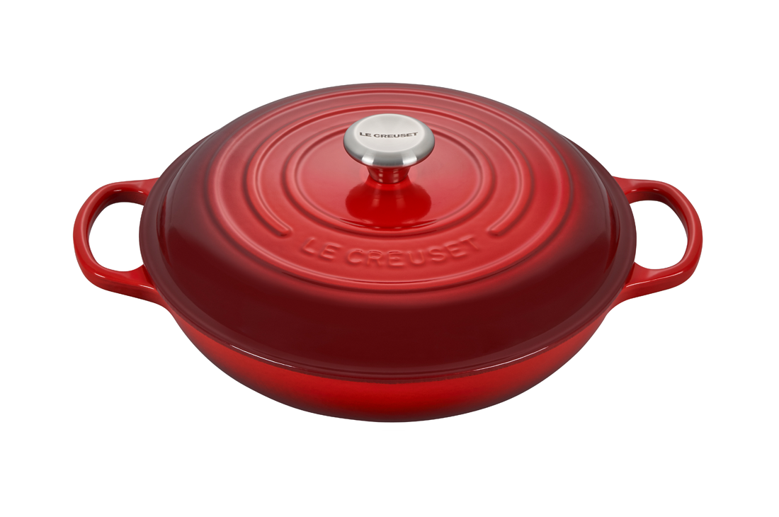 Red enameled cast iron Dutch oven with lid on white background