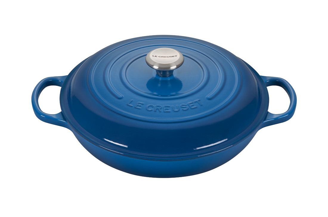 Blue enameled cast iron Dutch oven by Le Creuset on white background