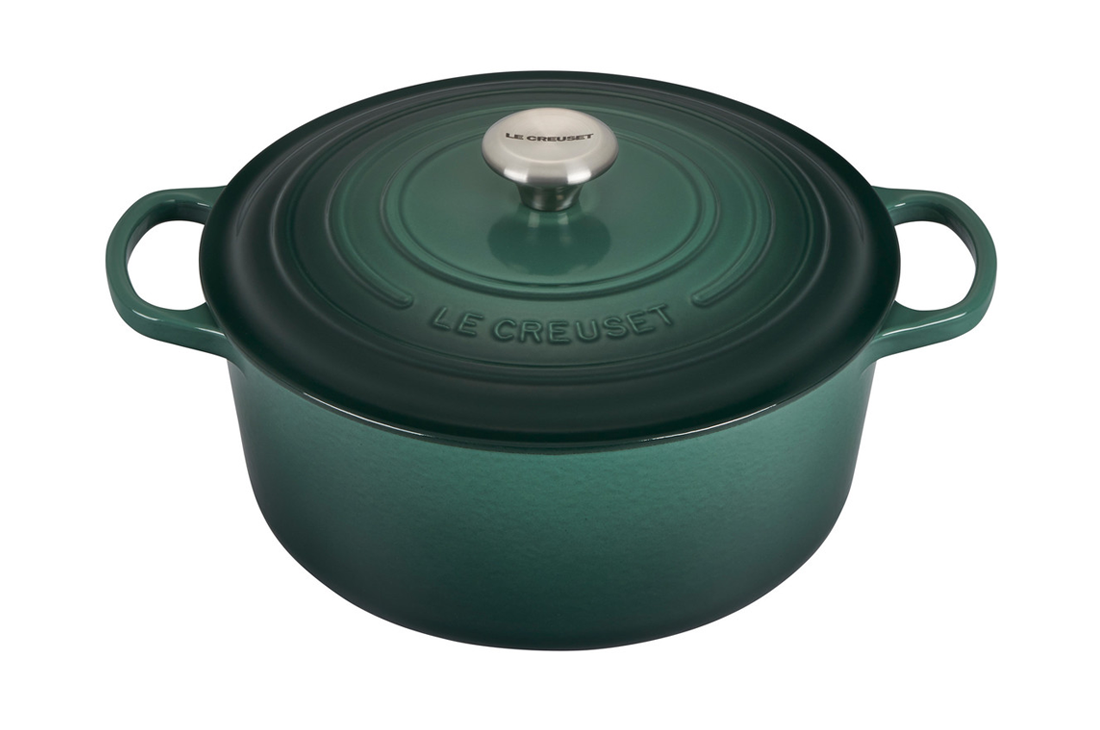Green enameled cast iron Le Creuset Dutch oven on white background