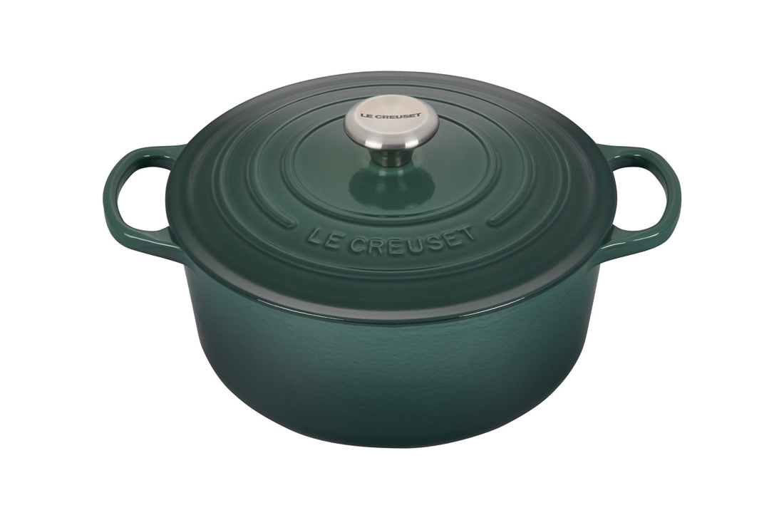 Green Le Creuset cast iron dutch oven on white background