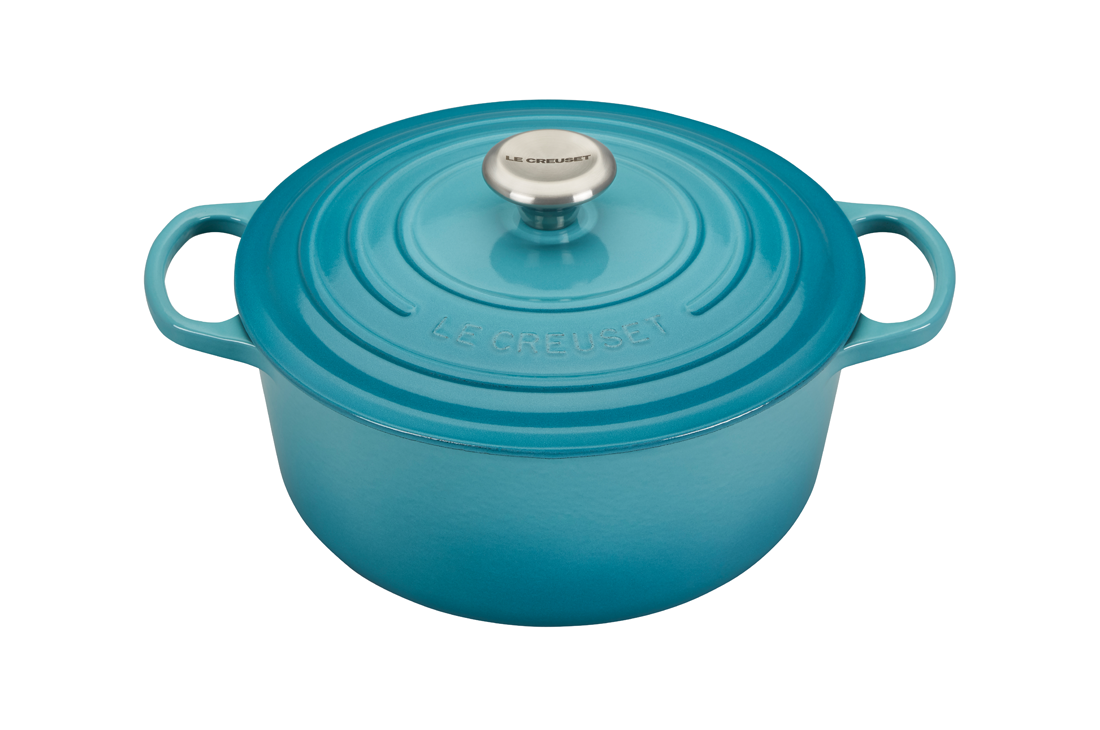 Blue enameled cast iron Dutch oven by Le Creuset on white background