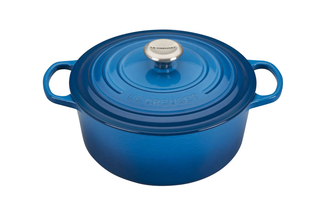 Blue enameled cast iron Dutch oven with lid on white background