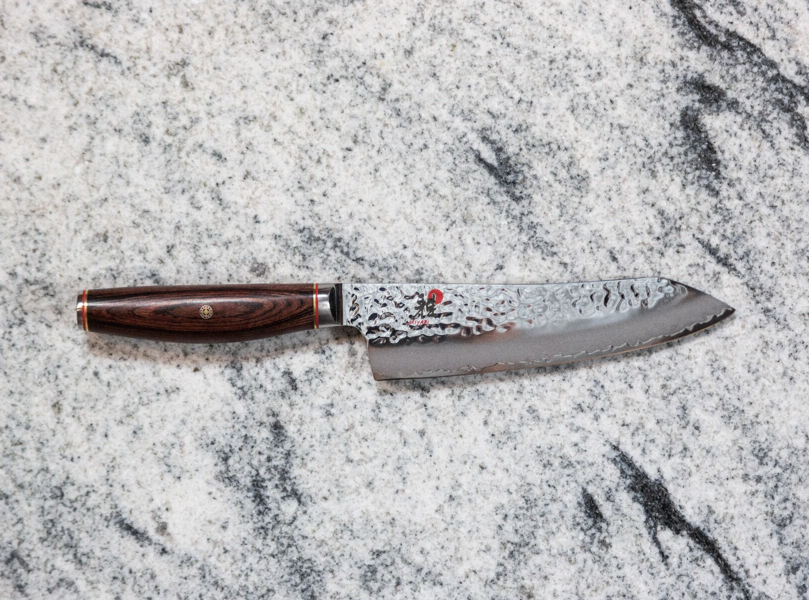 Damascus steel chef's knife with wooden handle on marble surface