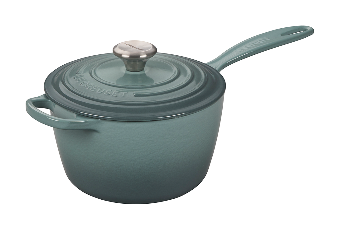 Teal enameled cast iron saucepan with lid on white background