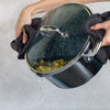 A person straining pasta water from a Zwilling Clad Ceramic CFX 6 qt Dutch Oven. 