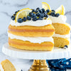 Lemon blueberry layer cake with cream on marble backdrop