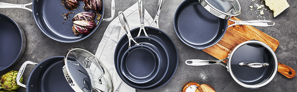 A table full of Zwilling Clad Ceramic CFX cookware, interspersed among other kitchen tools and ingredients.