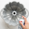 Nordic Ware Baker's Joy Non-Stick Spray is sprayed into a bundt pan.