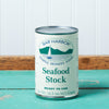 A can of Bar Harbor Foods Seafood Stock sits on a turquoise wooden table.