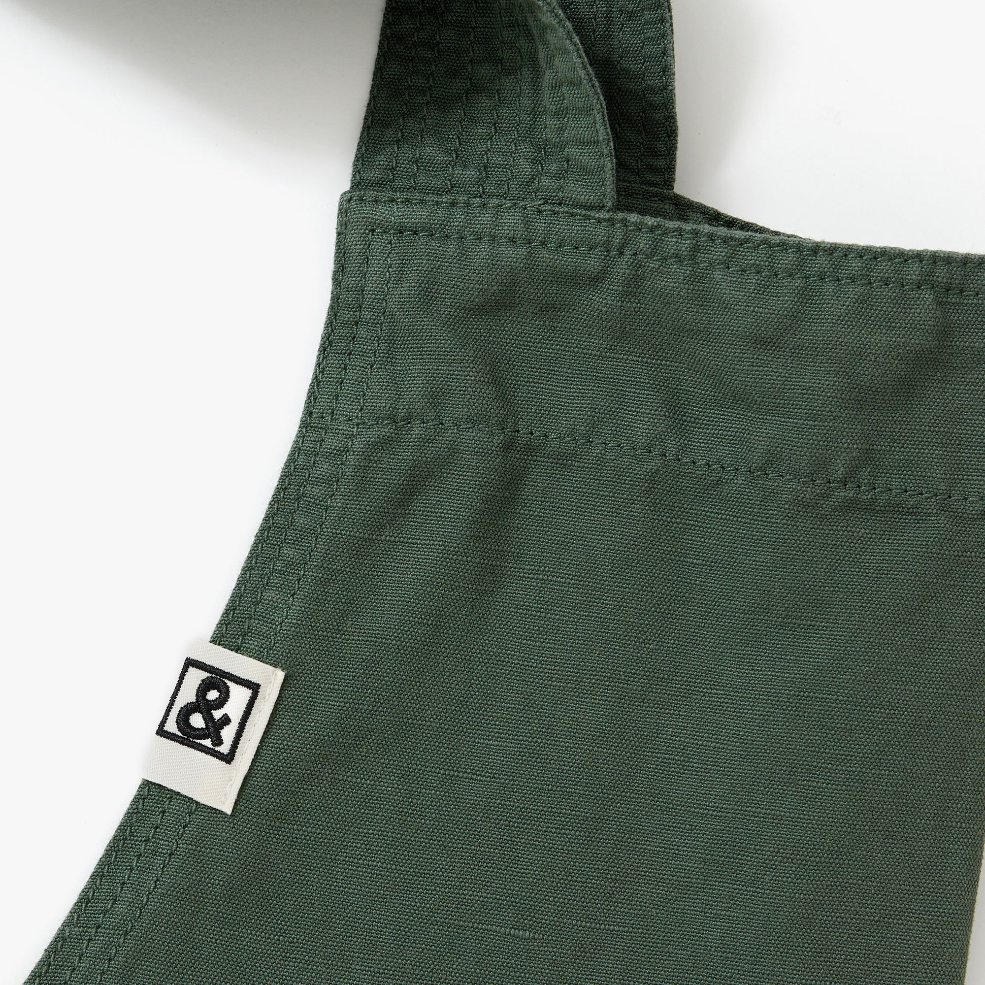 A close up shot of a Hedley & Bennett Broccolini green Smock.
