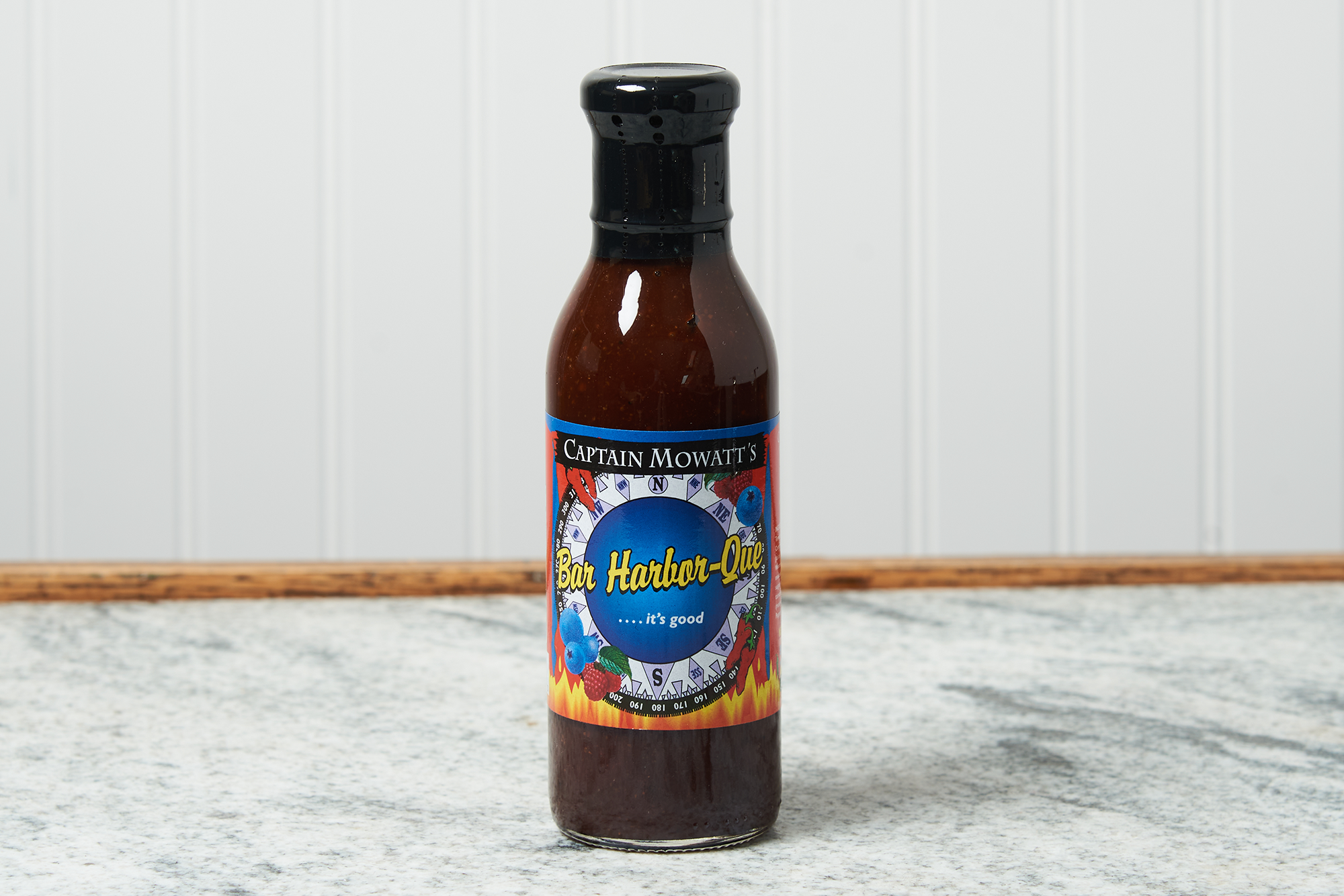A bottle Captain Mowatt's Bar Harbor-Que Sauce of sits on a marble countertop.