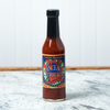 A bottle of Captain Mowatt's Canceaux Turbeaux Sauce sits on a marble countertop.