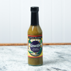 A bottle of Captain Mowatt's Greenie Sauce sits on a marble countertop.