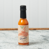 A bottle of Chad's Single Reef Hot Sauce sits on a marble countertop.