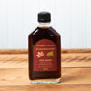 A bottle of Cobb's Hill Civil Union Maple Syrup sits on a brown wooden table.