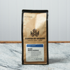 A bag of Coffee By Design Maine Maple Sundae coffee sits on a marble countertop.