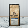A bag of Coffee By Design Maine Wild Blueberry coffee sits on a marble countertop.