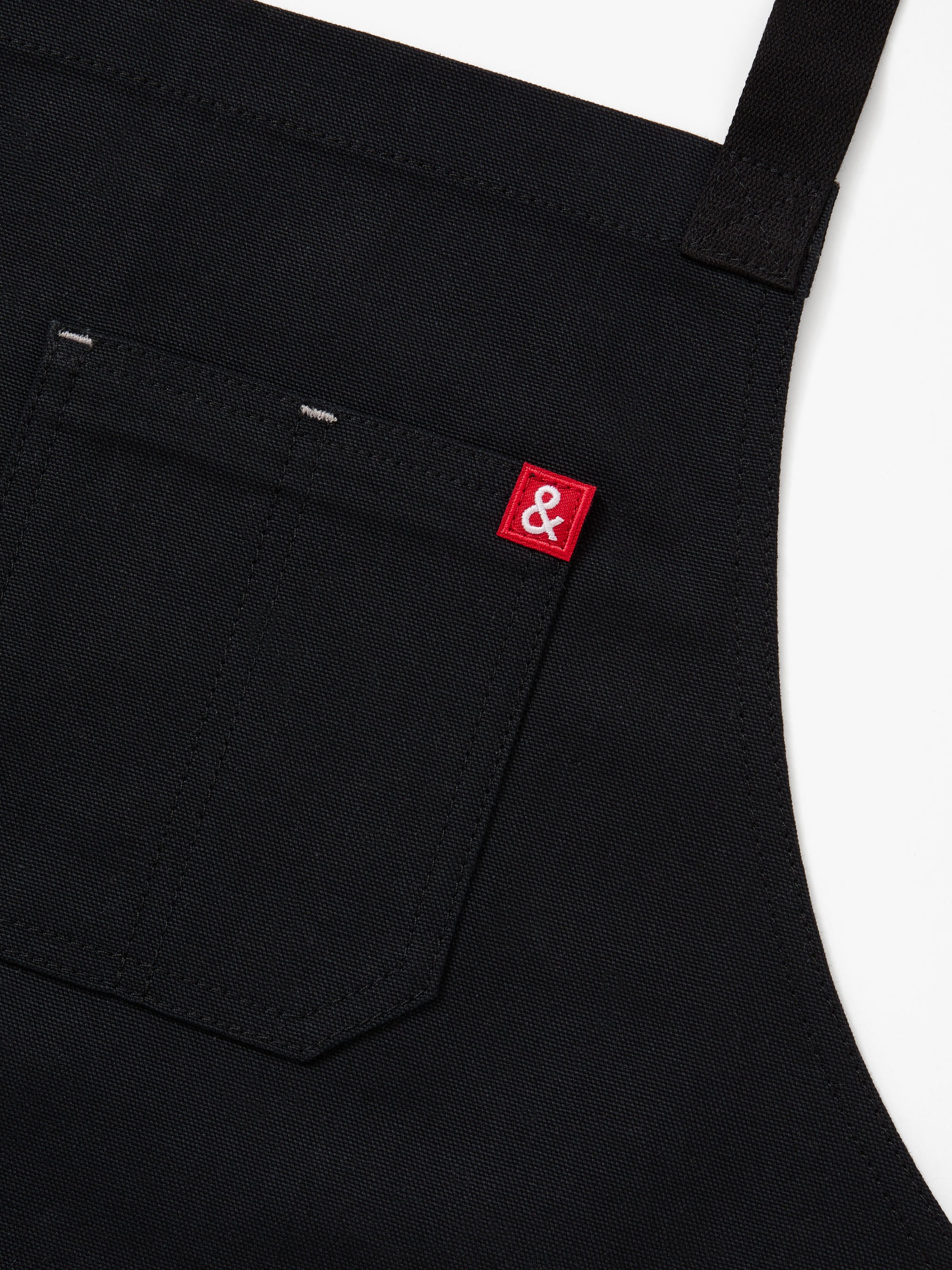 A close up shot of a Hedley & Bennett Caviar Black Crossback Apron.