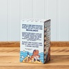 A rear-facing view of a box of Greek Sea Salt Flakes sitting on a wooden table.