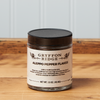 A jar of Gryffon Ridge Aleppo Pepper Flakes sits on a wooden tabletop.