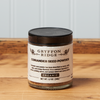 A jar of Gryffon Ridge Coriander Seed Powder sits on a wooden tabletop.
