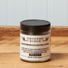 A jar of Gryffon Ridge Eastern River Cattle Cover sits on a wooden tabletop.