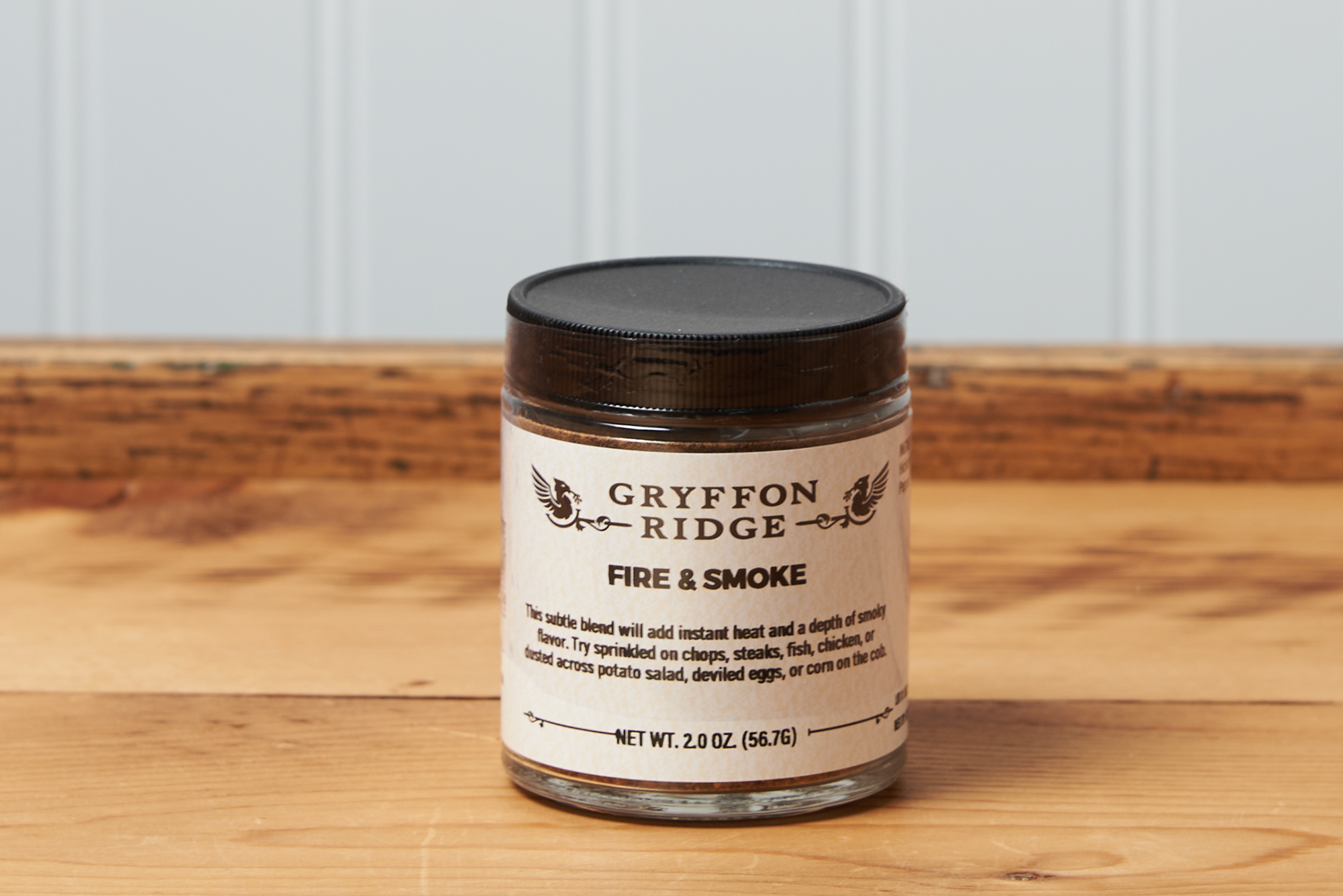 A jar of Gryffon Ridge Fire & Smoke sits on a wooden tabletop.