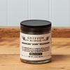 A jar of Gryffon Ridge Jamaican “Jerk” Seasoning sits on a wooden tabletop.