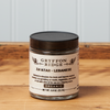 A jar of Gryffon Ridge Lebanese Za’atar sits on a wooden tabletop.