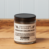 A jar of Gryffon Ridge Moroccan Grilling Blend sits on a wooden tabletop.