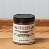 A jar of Gryffon Ridge Senor Pistole’s Mild Chili Seasoning sits on a wooden tabletop.