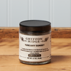 A jar of Gryffon Ridge Tuscany Sunset sits on a wooden tabletop.