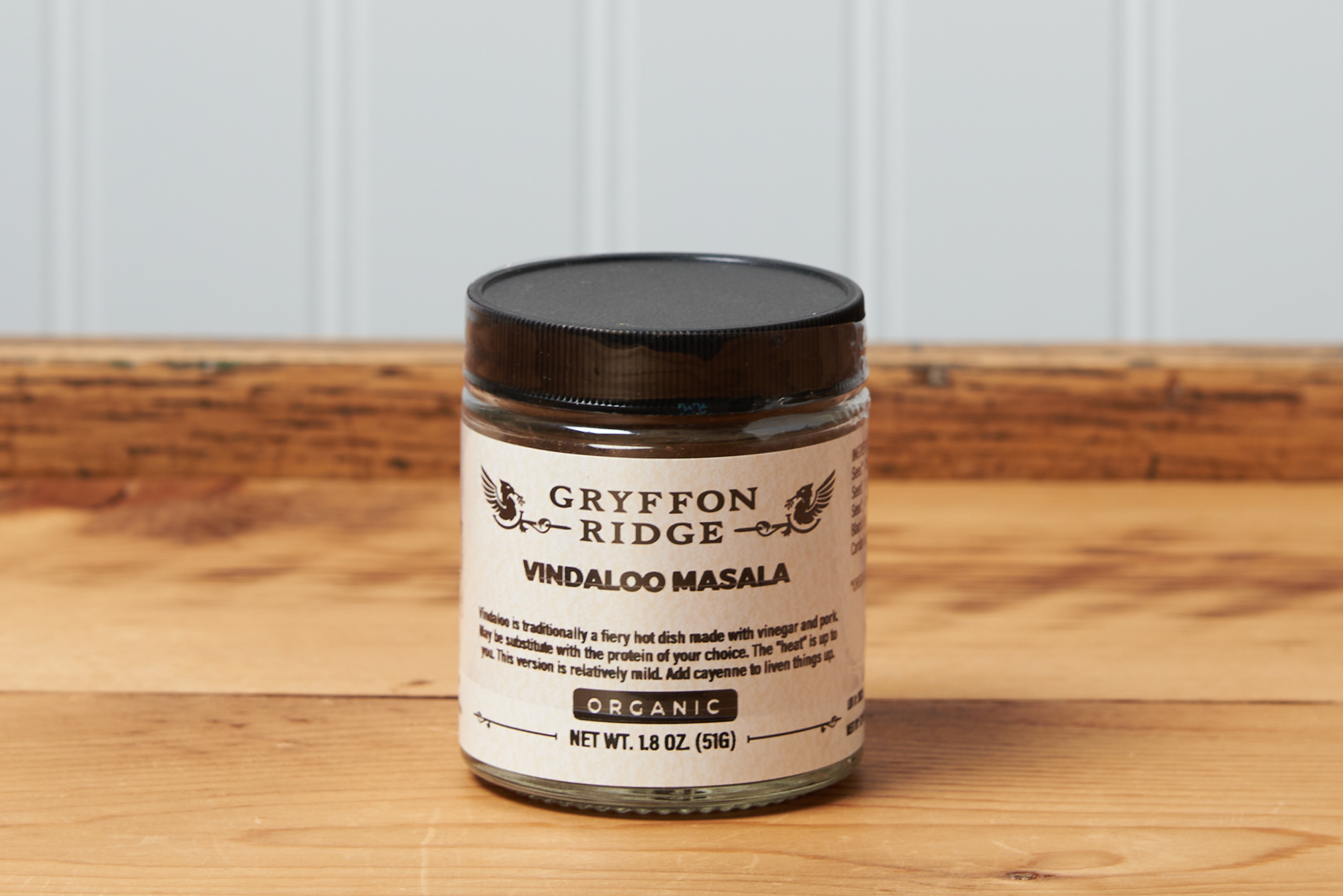 A jar of Gryffon Ridge Vindaloo Masala sits on a wooden tabletop.