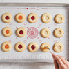 Baking sheet with round cookies being filled with jam on a King Arthur Baking Company Cookie Mat.