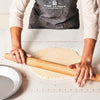 Person rolling out dough with a wooden rolling pin on a King Arthur Baking Company Rolling Mat.