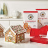 A King Arthur Baking Company 3-D Gingerbread Cutter Set sits alongside two completed gingerbread houses and boxes of baking mix on a white countertop.