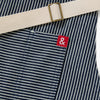 A close up shot of a Hedley & Bennett Hickory Stripe Essential Apron over a white background.