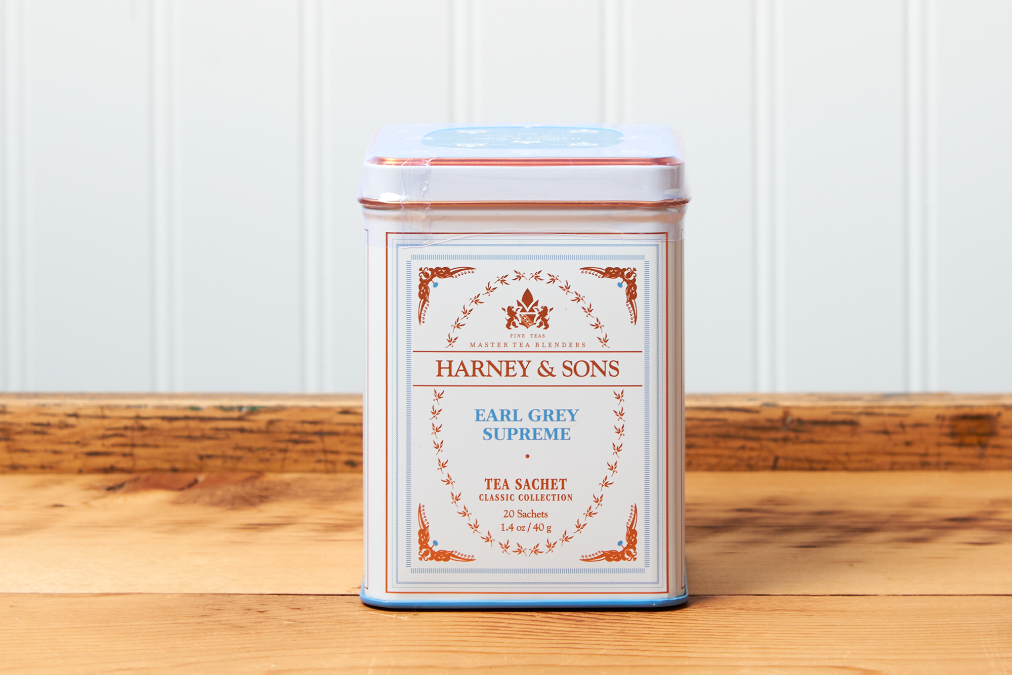 A tin of Harney & Sons Earl Grey Supreme tea sits on a wooden countertop.
