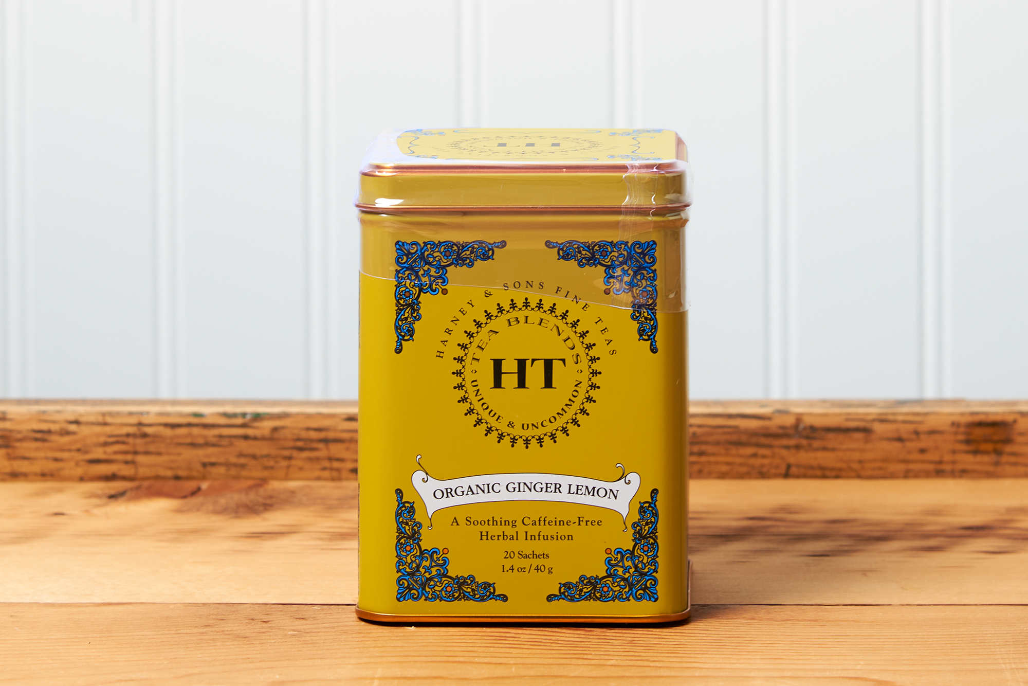 A tin of Harney & Sons Ginger Lemon tea sits on a wooden countertop.