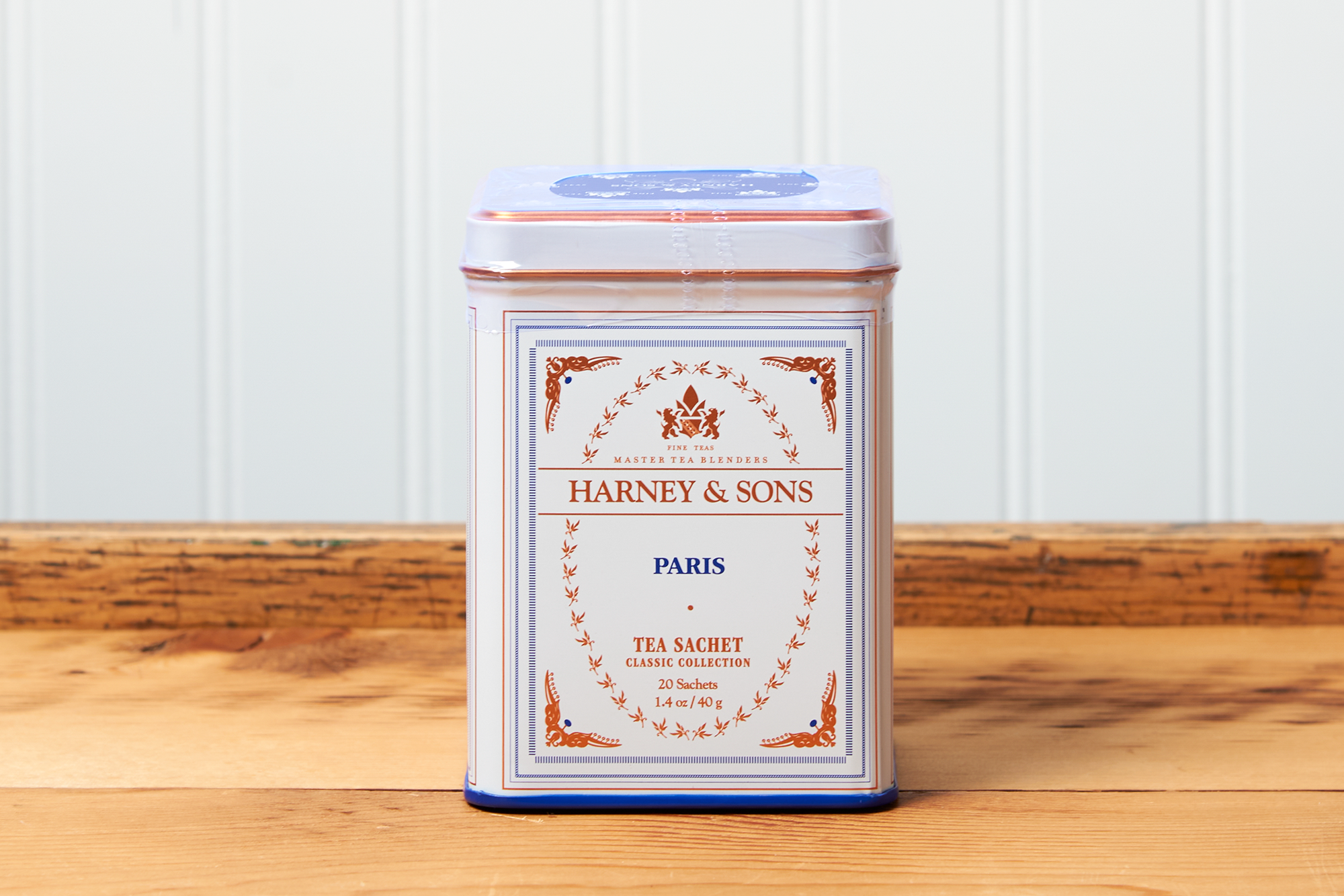 A tin of Harney & Sons Paris tea sits on a wooden countertop.